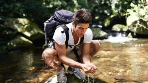 Fit Man refreshing himself with water from the river